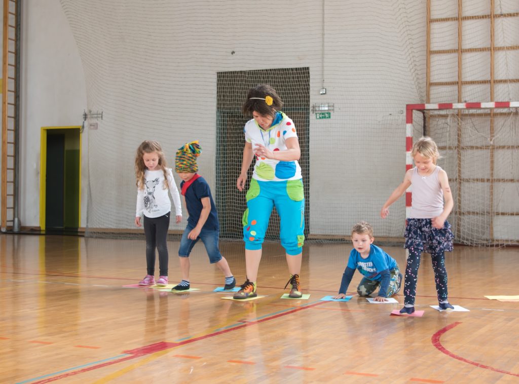 otroci in animatorka v telovadnici tečejo s paprijem