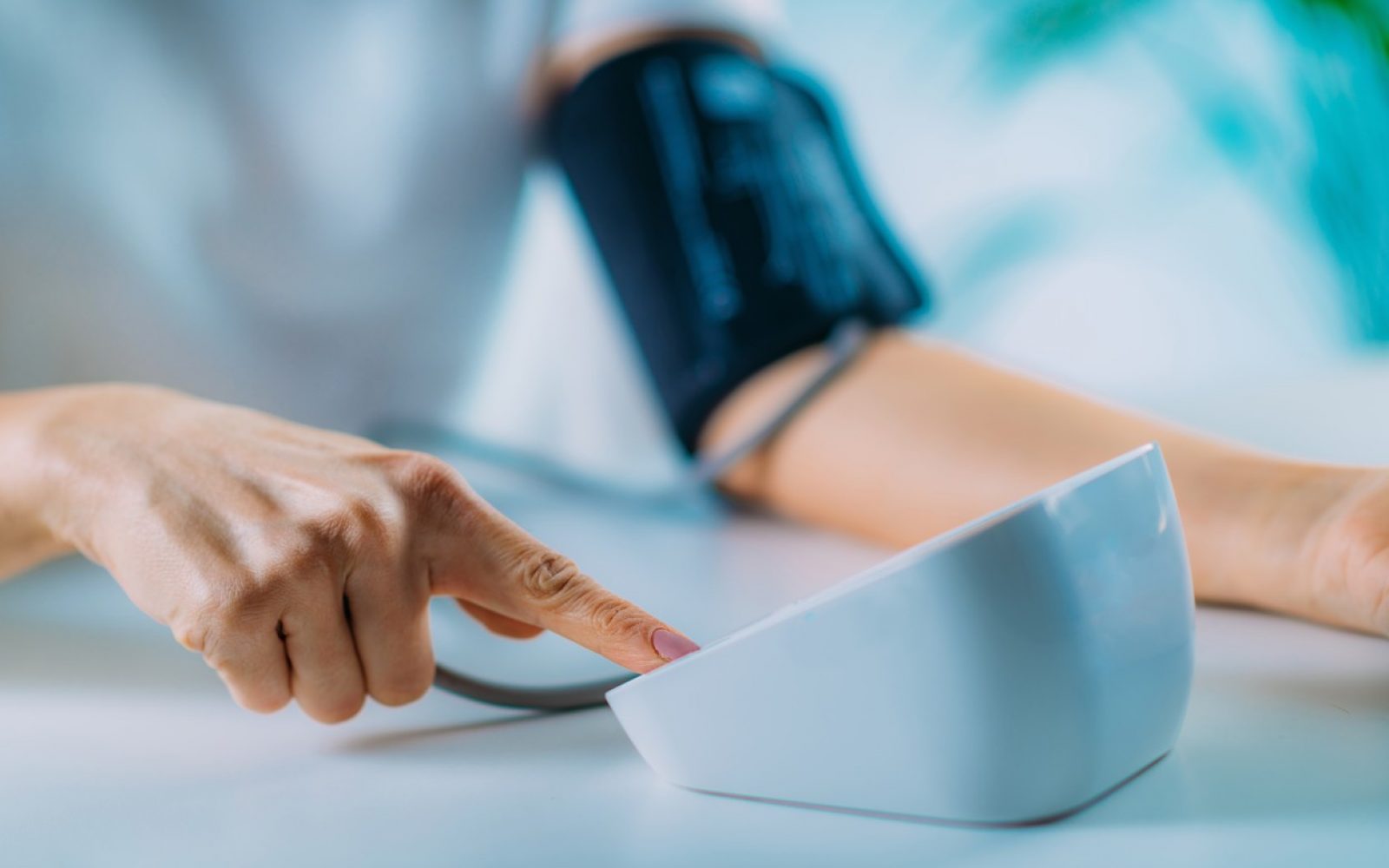 Oseba si meri krvni tlak z domačim merilnikom