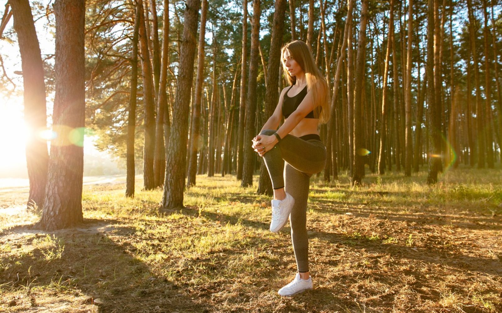 Lepa ženska se pred vadbo razteza