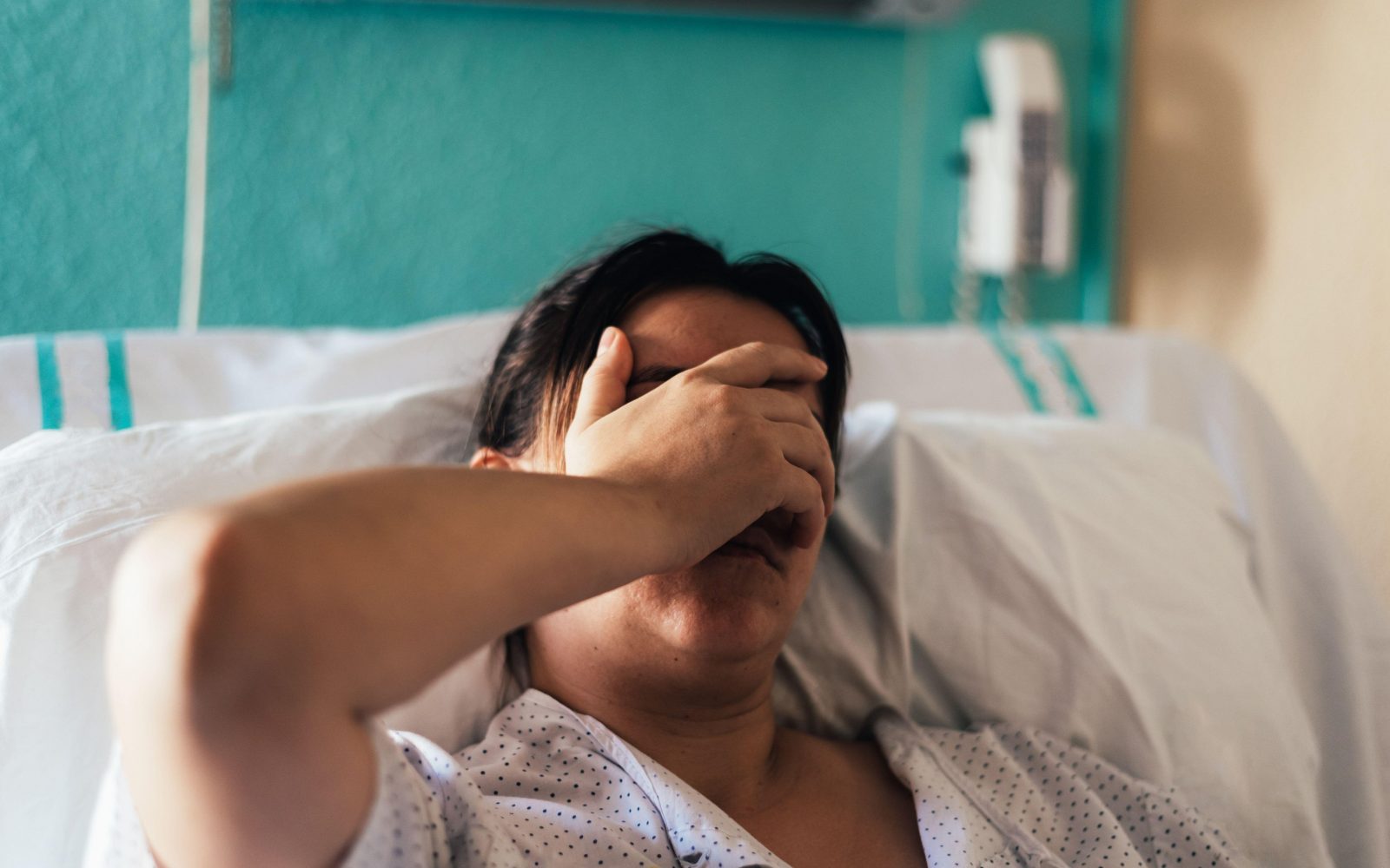 Ženska leži v bolniški postelji v bolnici