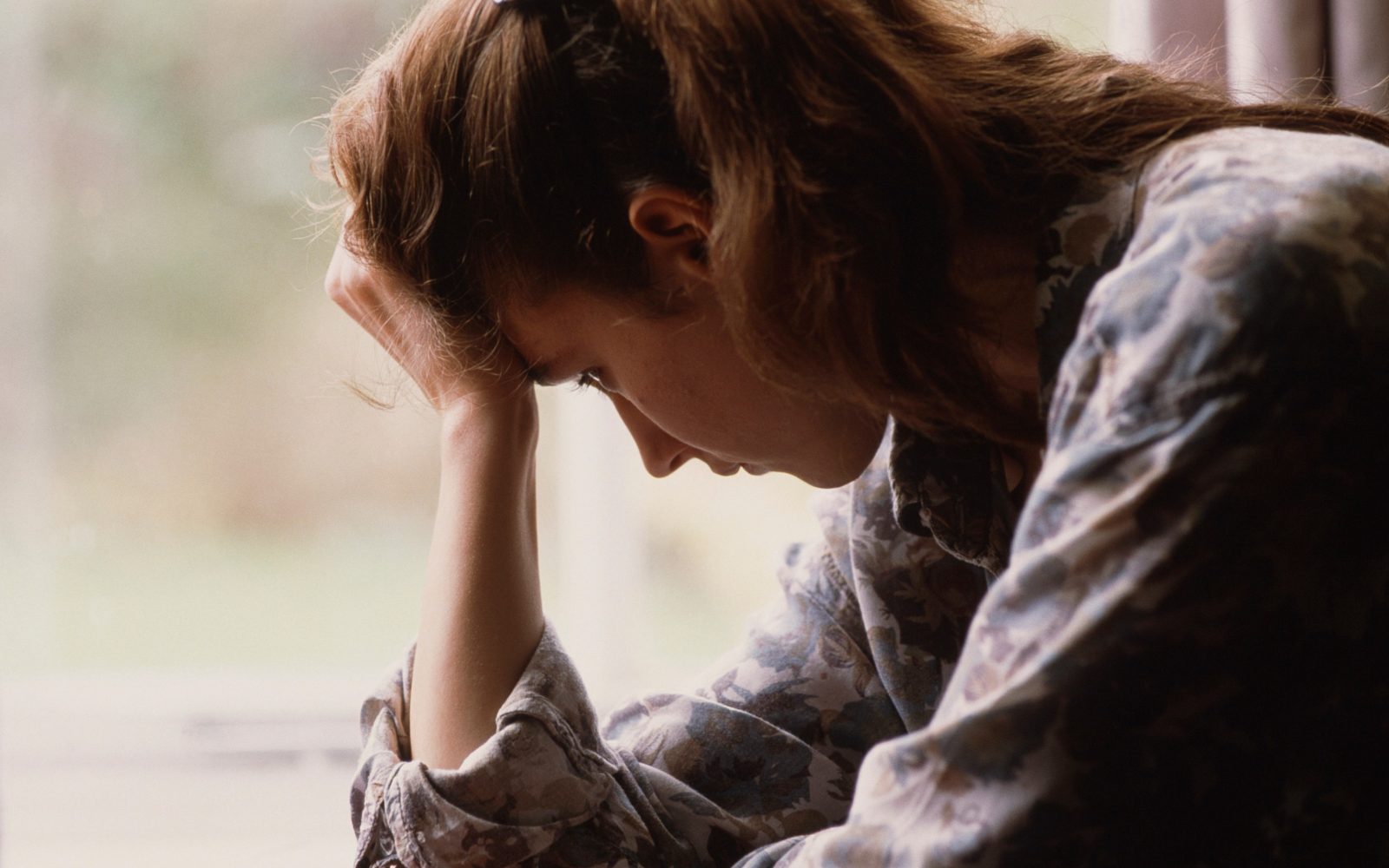 Otožna ženska se drži za glavo