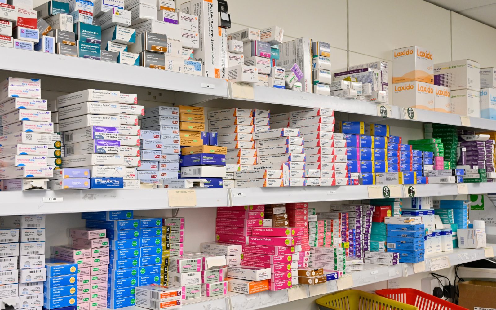 Slika polic v lekarni s številnimi zdravili