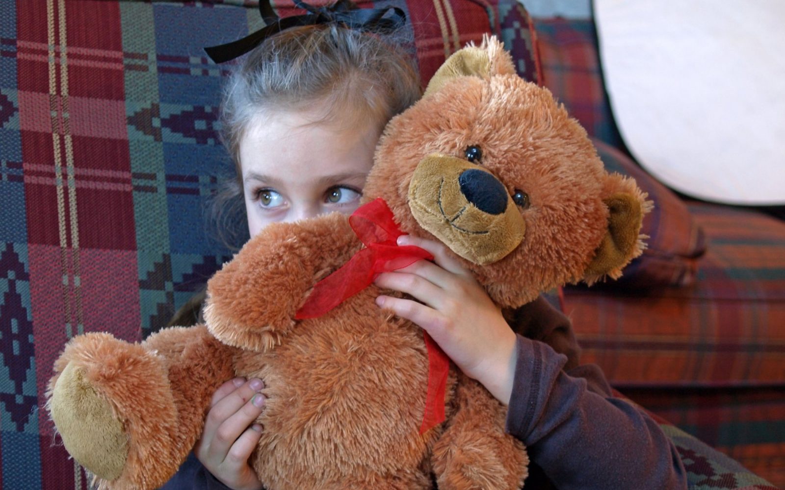 Deklica se skriva za medvedkom