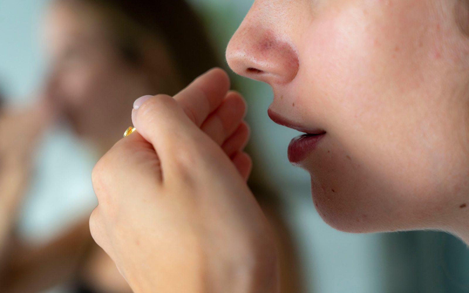 Slab ustni zadah, ženska drži roke pred ustmi