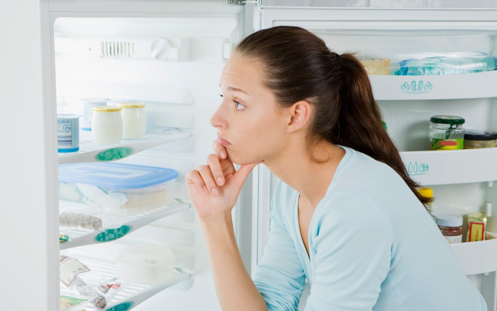 Ženska gleda v hladilnik