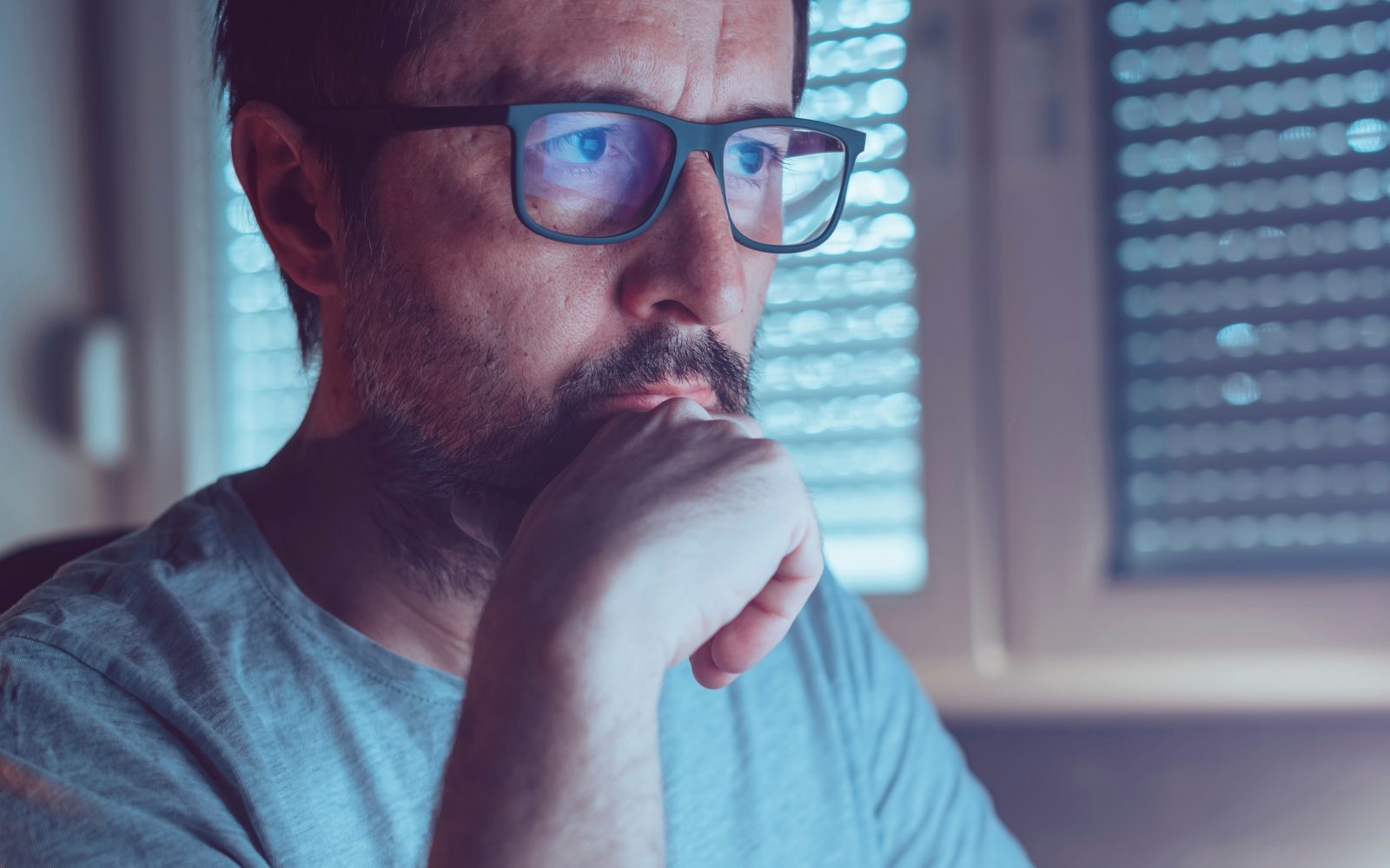 Moški z očali gleda v ekran