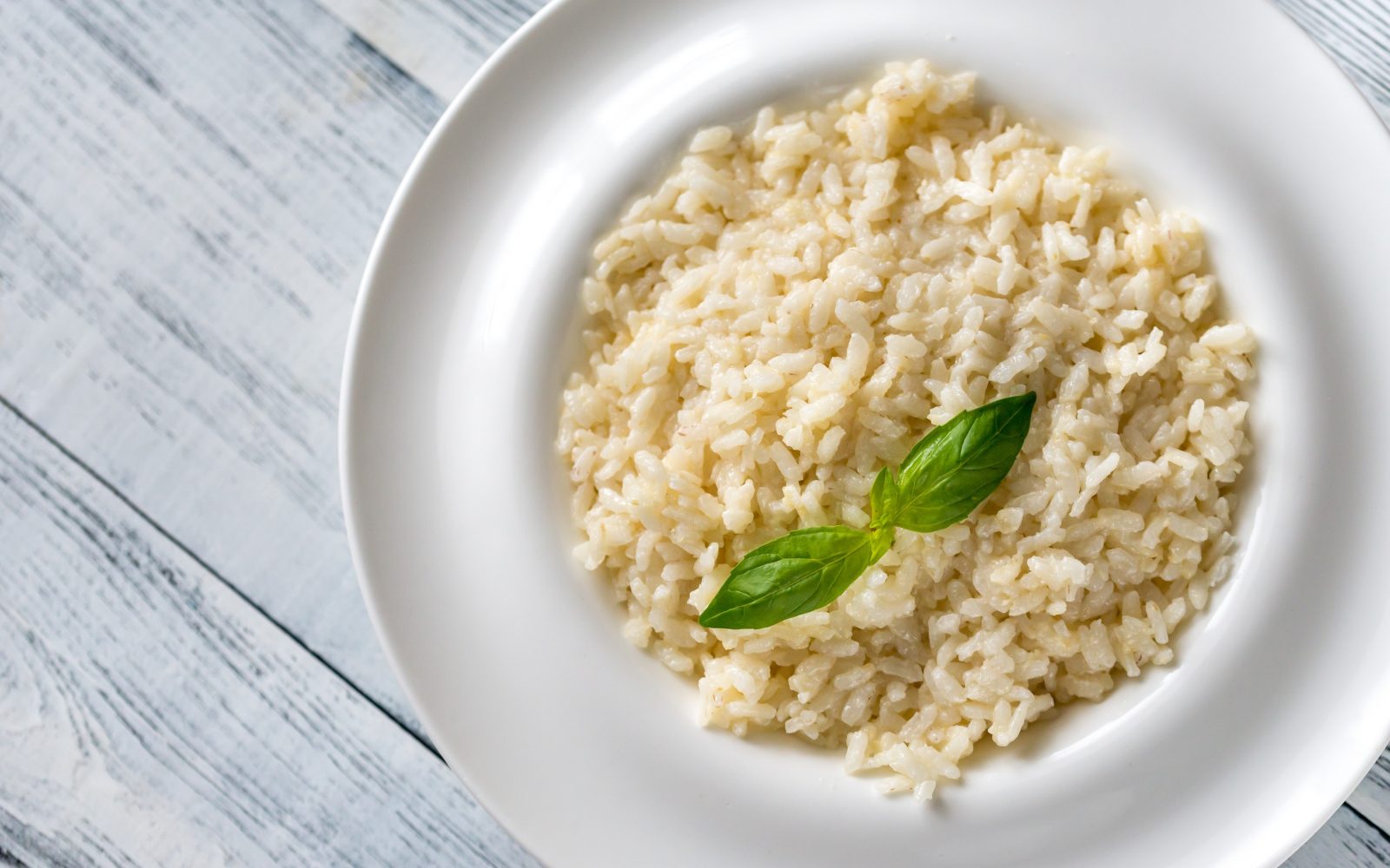 riž na krožniku z listkom bazilike