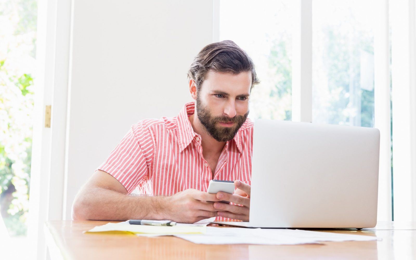 Moški na telefonu in računalniku
