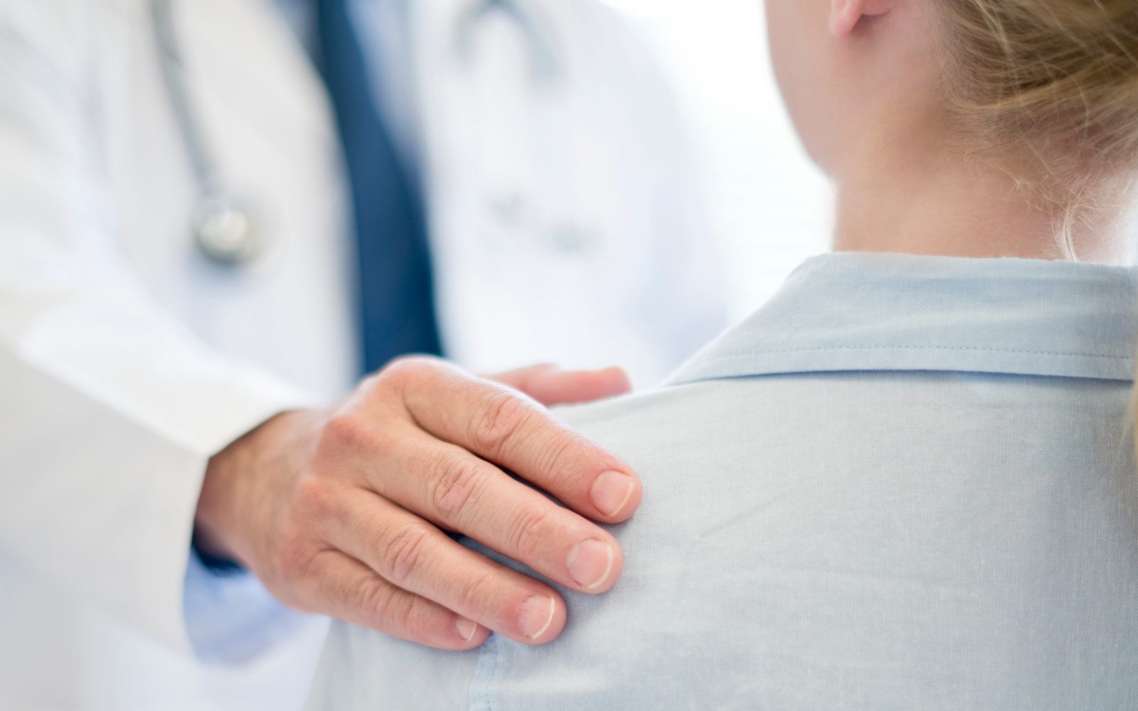 Zdravnik drži bolnico za rame