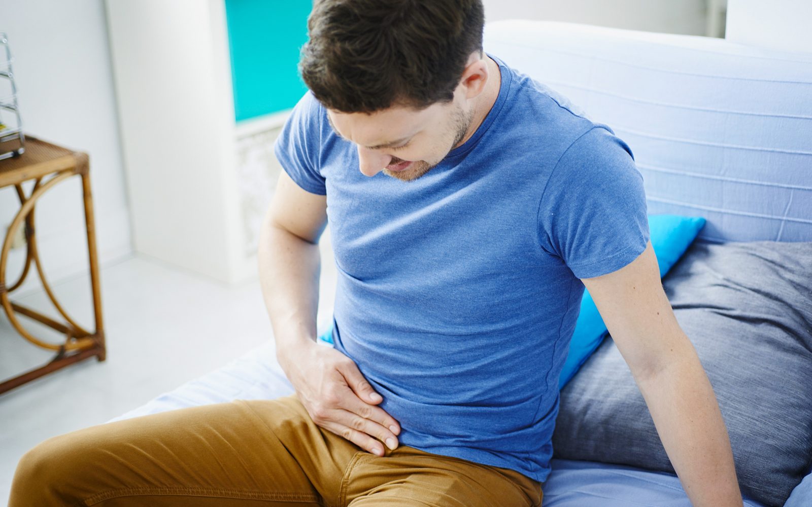 Moški se z roko drži za trebuh, ker ga boli