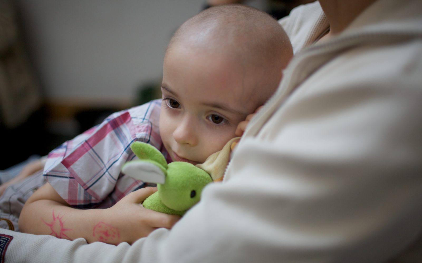 Žalosten majhen otrok se stiska k odraslemu