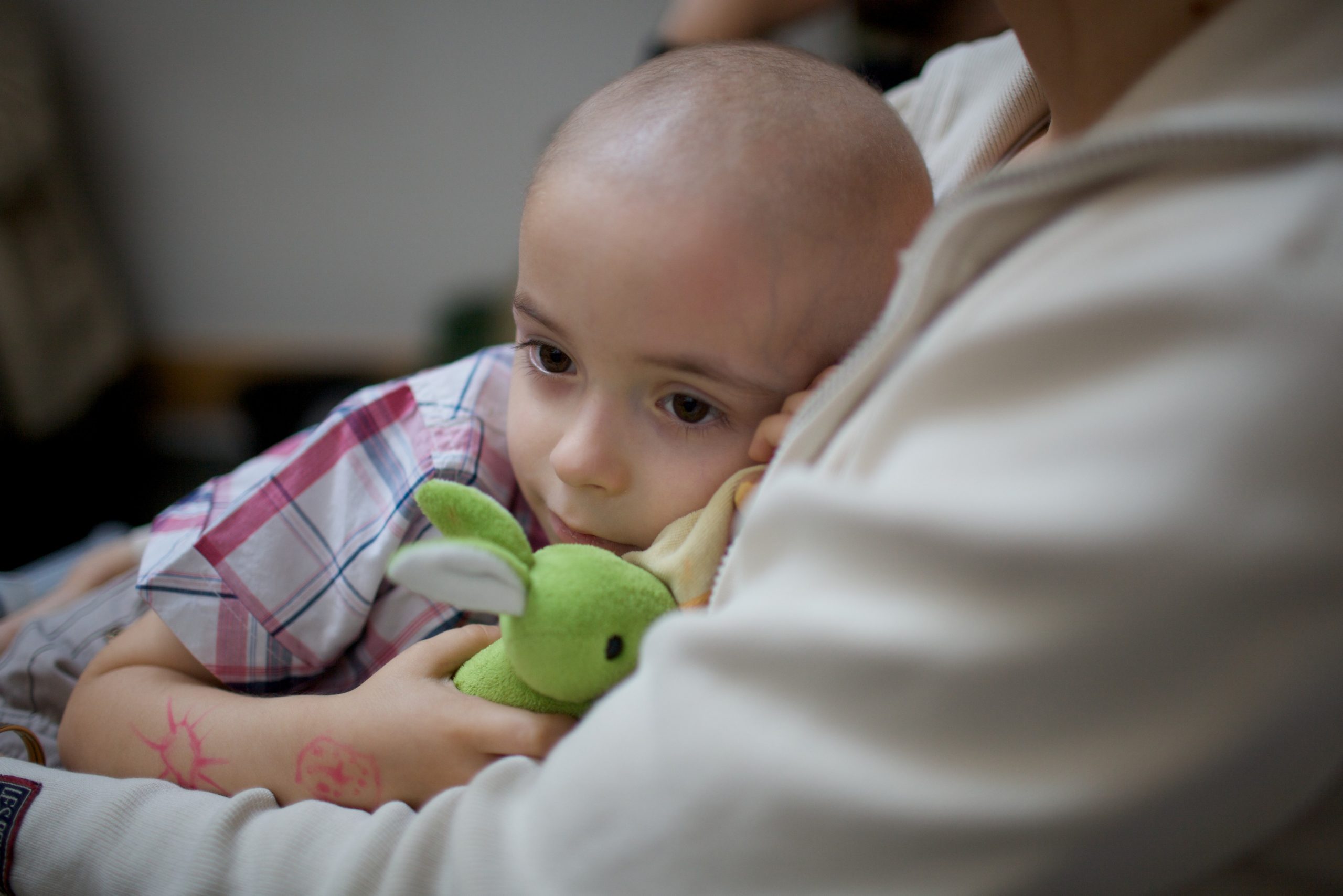 Žalosten majhen otrok se stiska k odraslemu