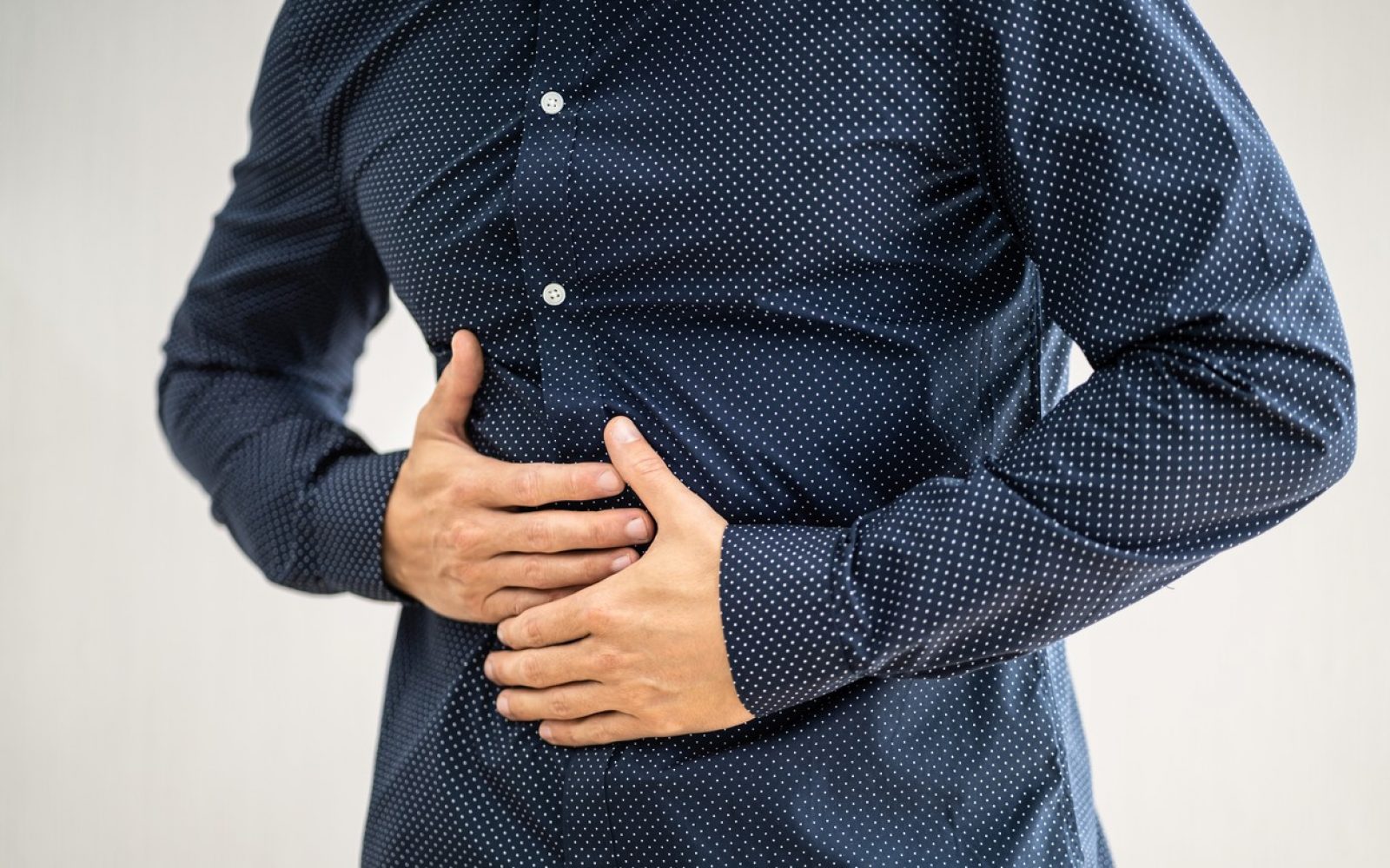 moški se drži za trebuh zaradi bolečin