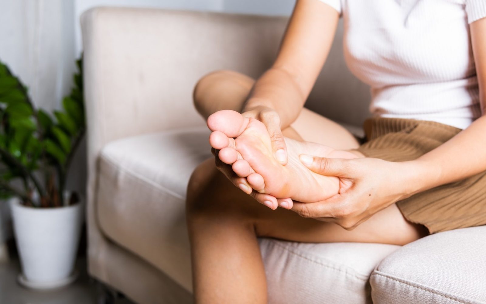 Ženska si gleda in masira noge