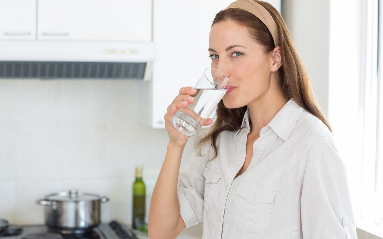 Lepa ženska iz kozarca pije vodo