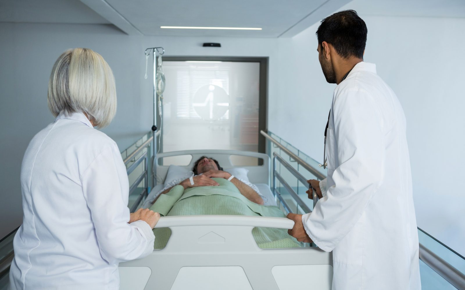 Dva zdravnika po bolnici potiskata voziček