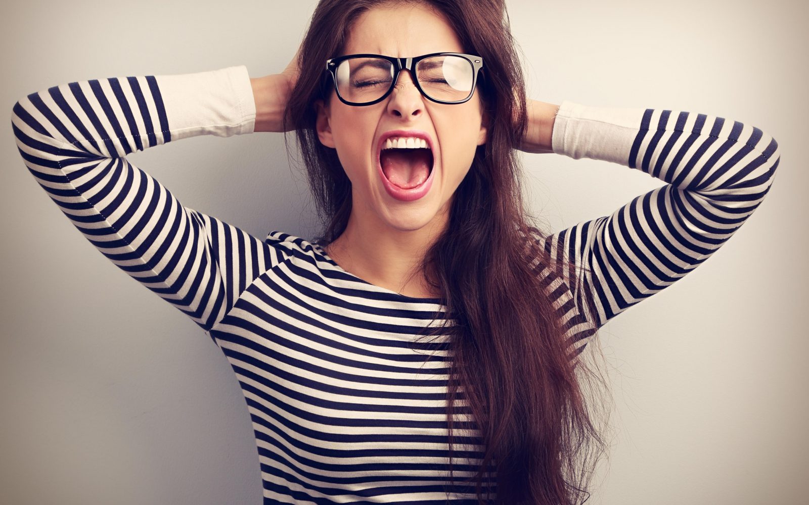 Ženska se drži za ušesa in kriči