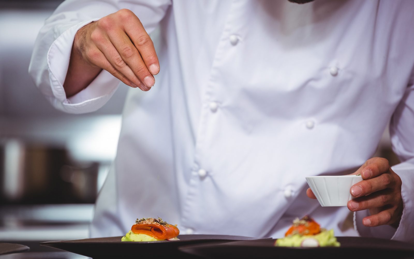 Kuhar daje začimbe na jed