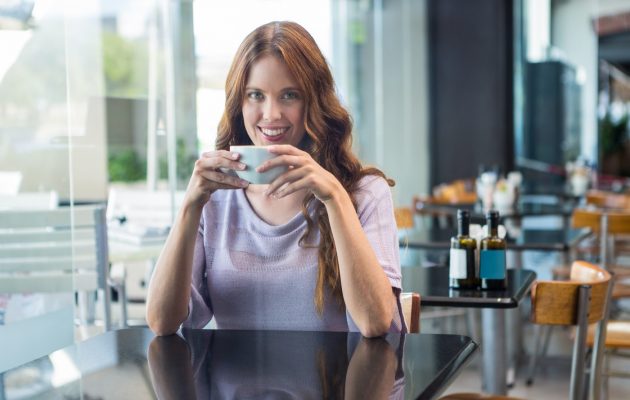 Ženska drži v rokah skodelico kave