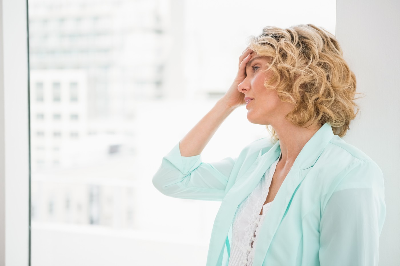 Lepa ženska se drži za glavo, ker jo pesti glavobol