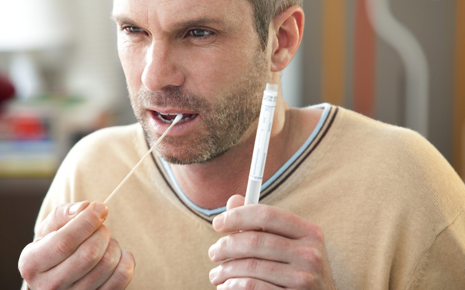 Moški med opravljanjem testa iz sline za diagnostične namene.