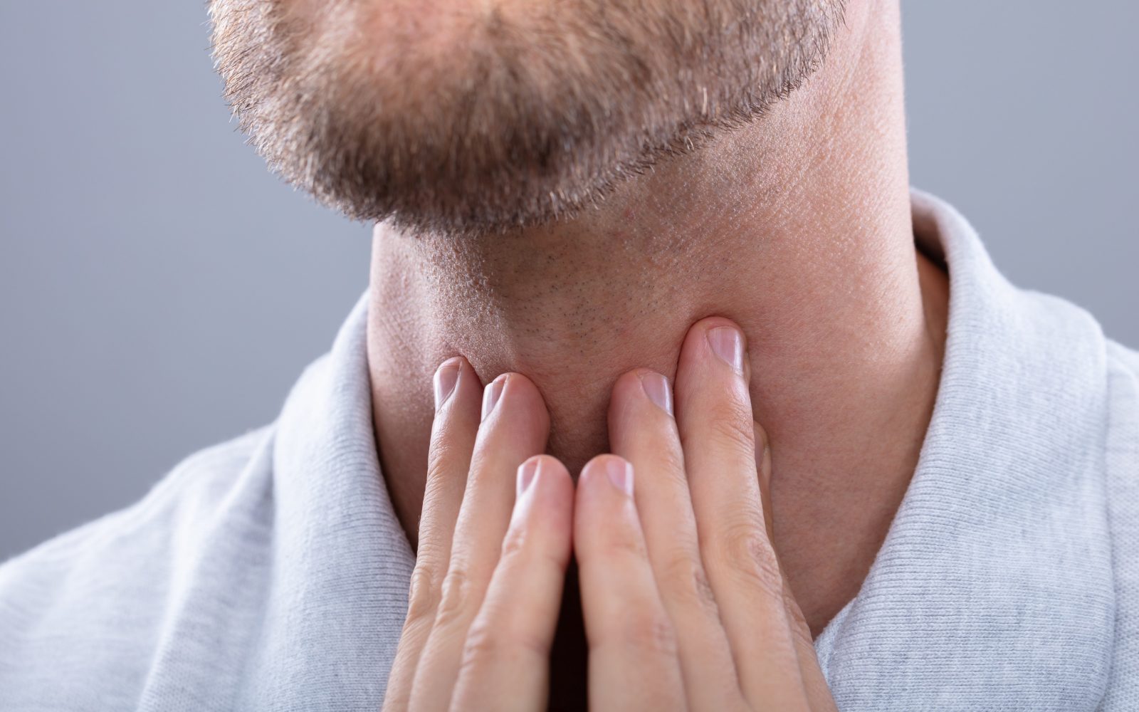 Moški se dotika vratu