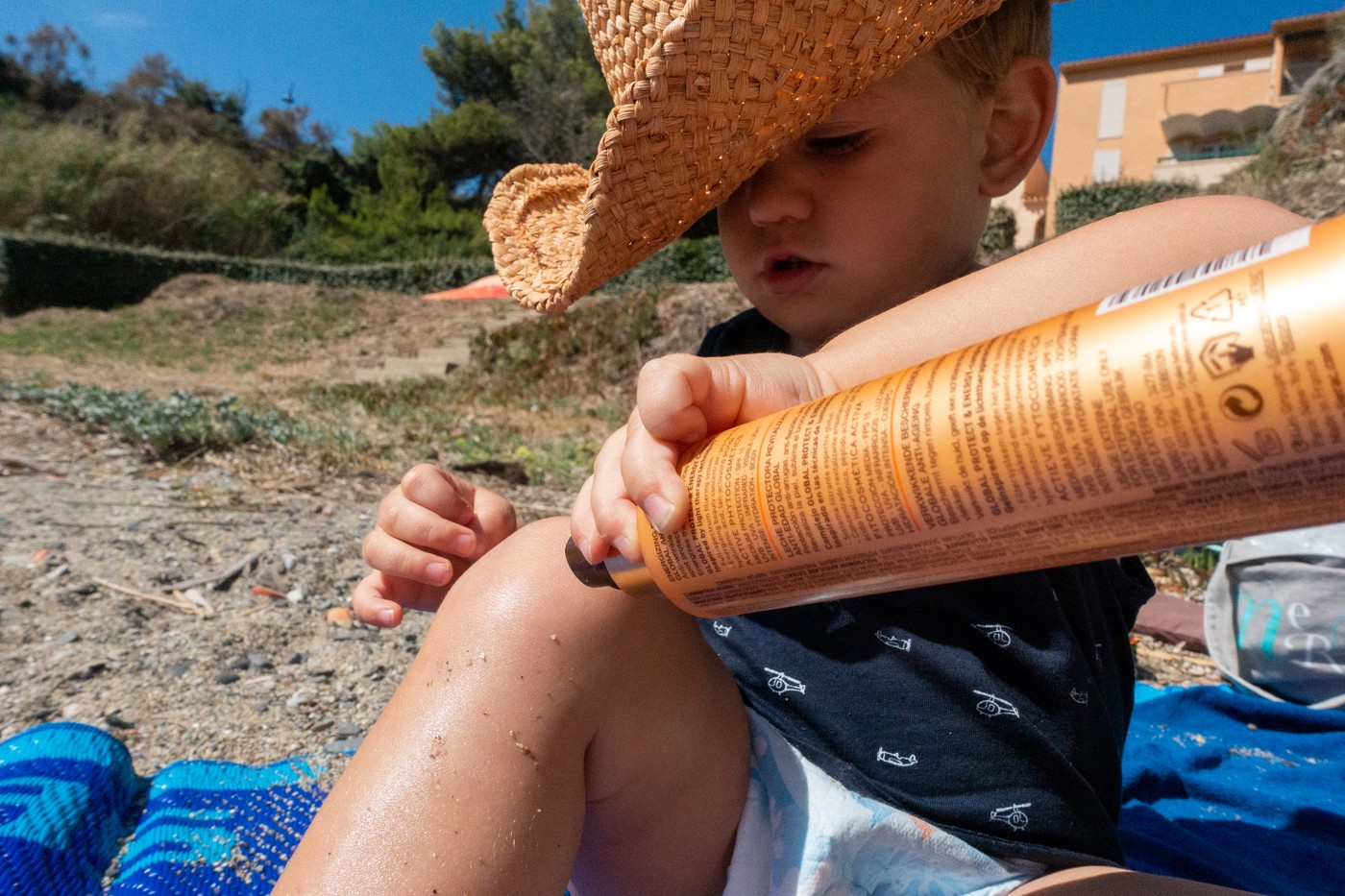 Otrok s klobukom in kremo za sončenje