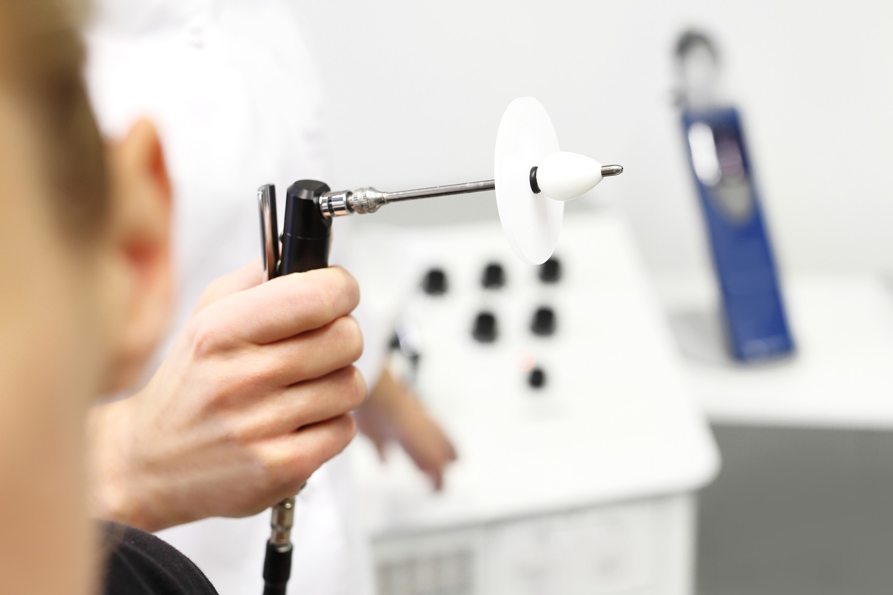 Slika prikazuje zdravstveno napravo, ki se uporablja za pregled in diagnozo težav s sluhom. Pravilna diagnostika je ključna za zgodnje odkrivanje in zdravljenje senzorično-nevralne izgube sluha ter drugih slušnih motenj.