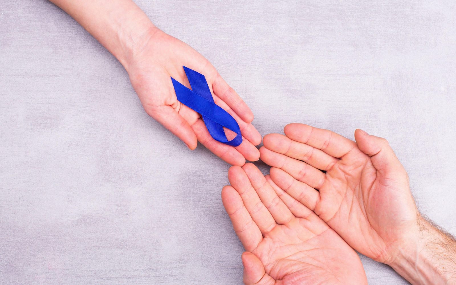 Ženska drži modro pentljo za ozaveščanje, simbol v moških rokah, rak debelega črevesa, kolorektalni rak