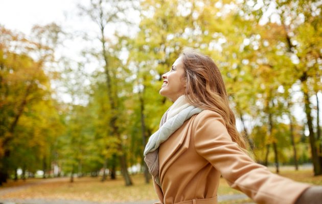 Nasmejana ženska v lepem jesenskem dnevu