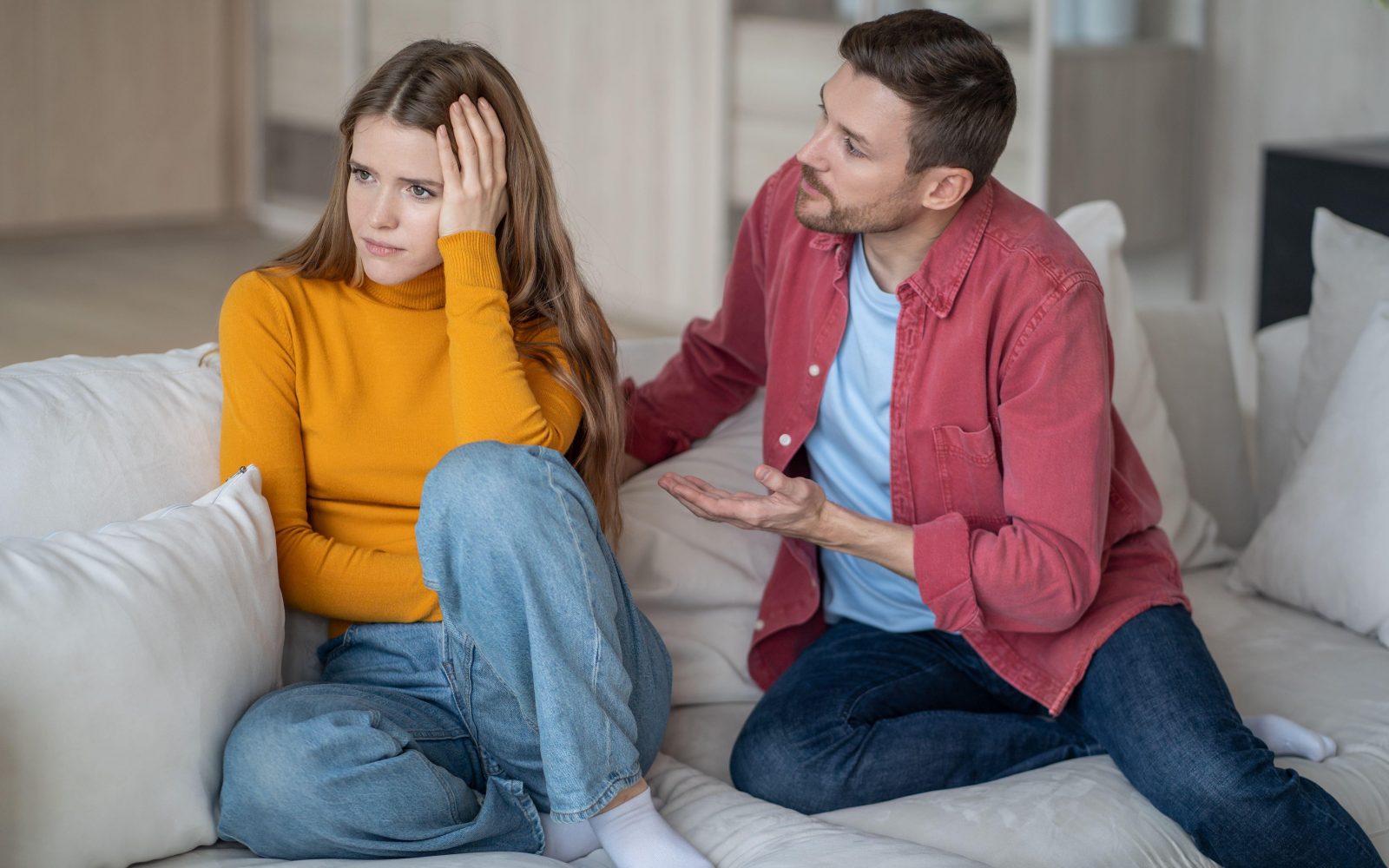 Jezna in užaljena ženska in moški, ki se ji opravičuje, ji razlaga