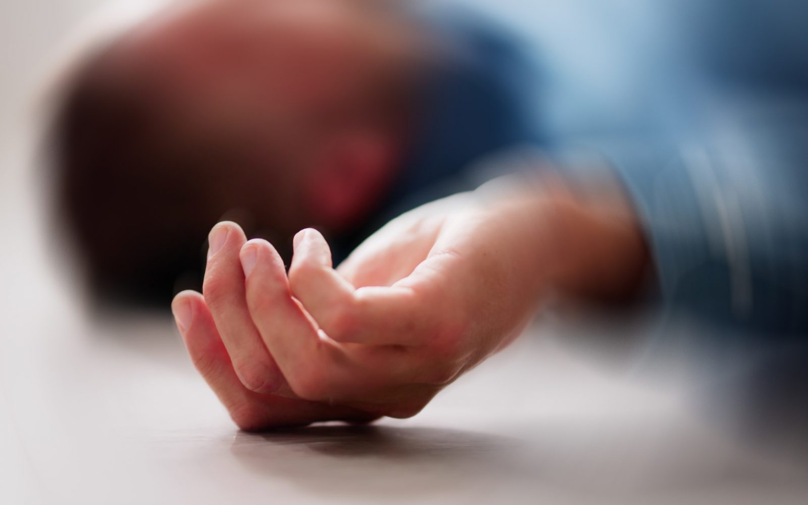 Moški leži na tleh po epileptičnem napadu