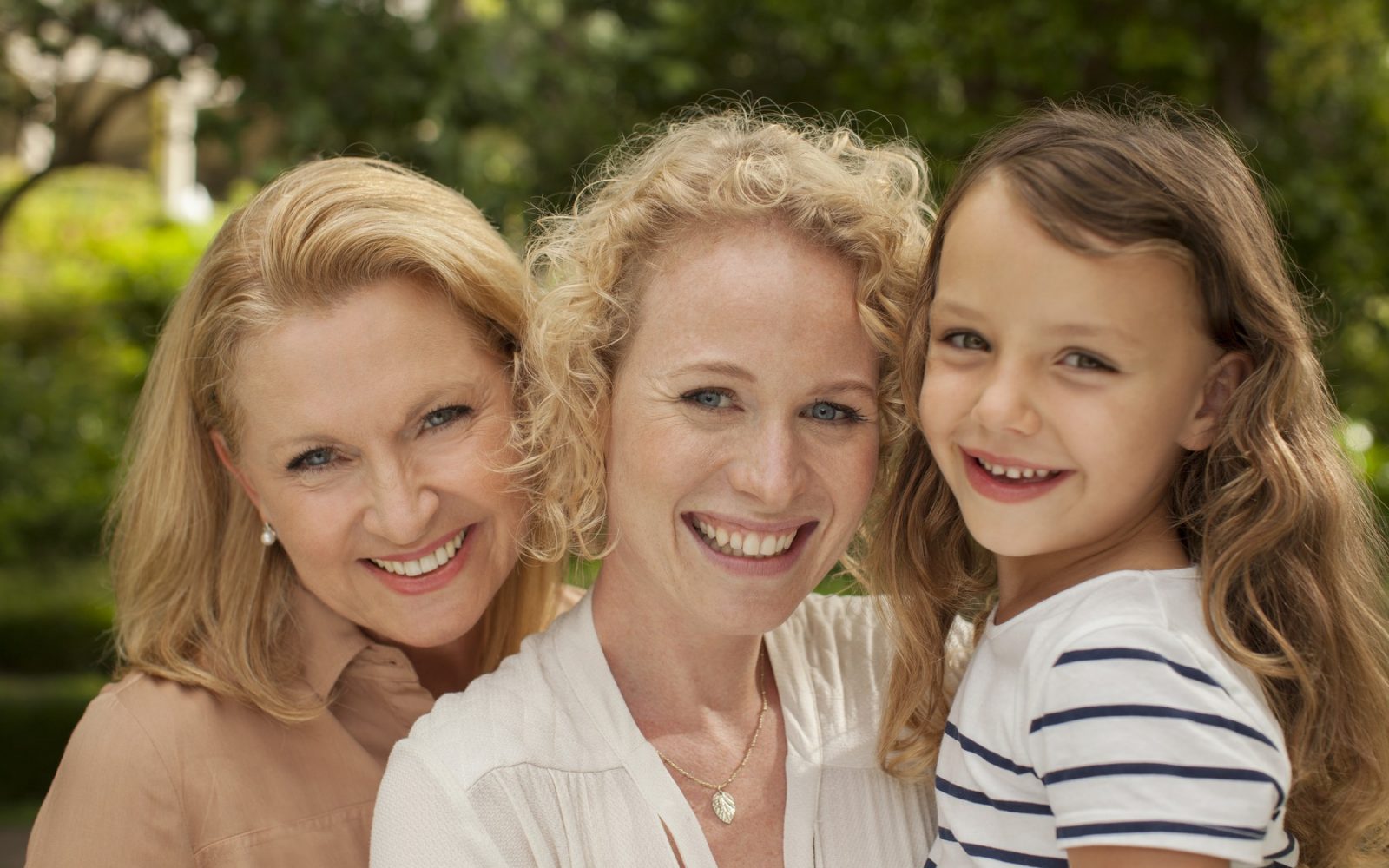 Tri ženske generacije - deklica, mama, babica (nasmejane)