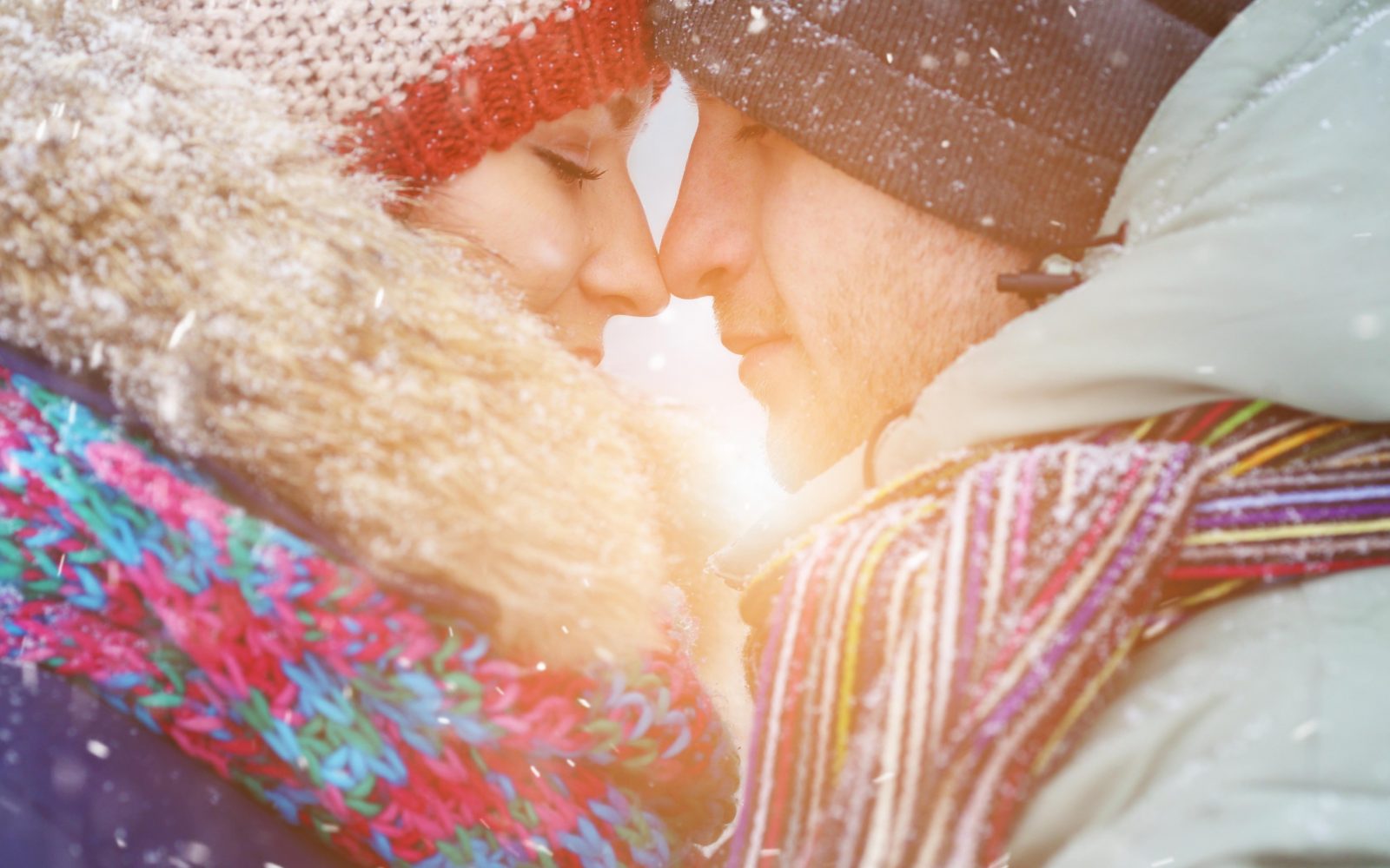 Zaljubljeni par se objema oziroma noska, sta nekje zunaj, zimski letni čas