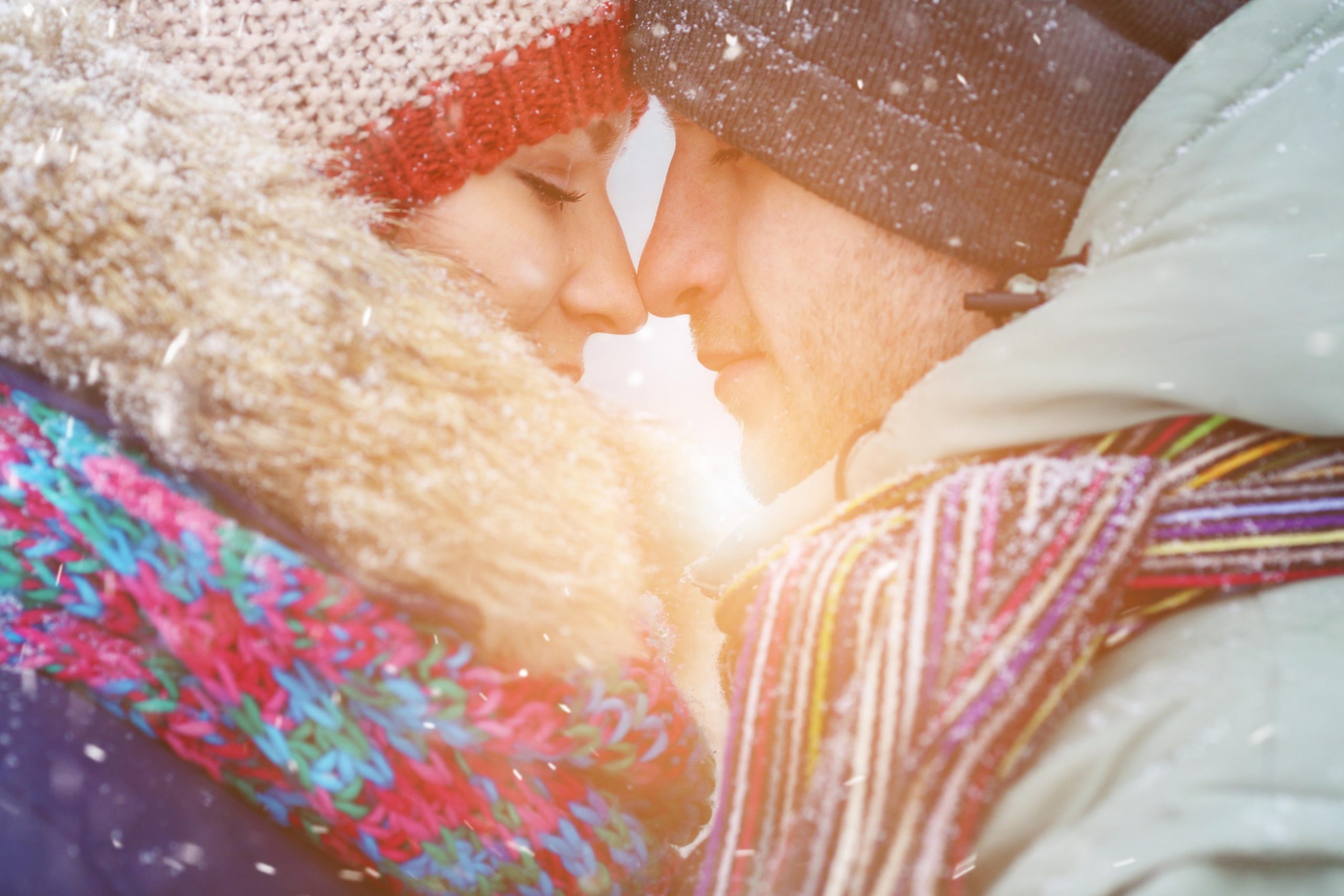 Zaljubljeni par se objema oziroma noska, sta nekje zunaj, zimski letni čas