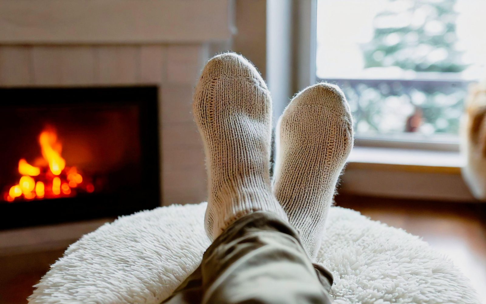 Nekdo sedi z nogami, dvignjenimi v zrak, in v toplih nogavicah