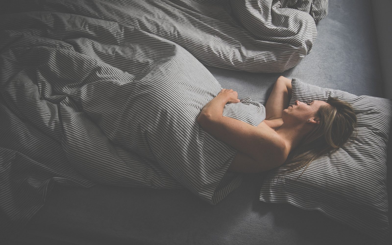 Lepa ženska spi v postelji