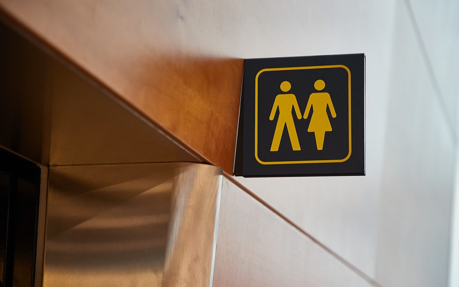 Oznaka za stranišče z moško in žensko silhueto v sodobni stavbi