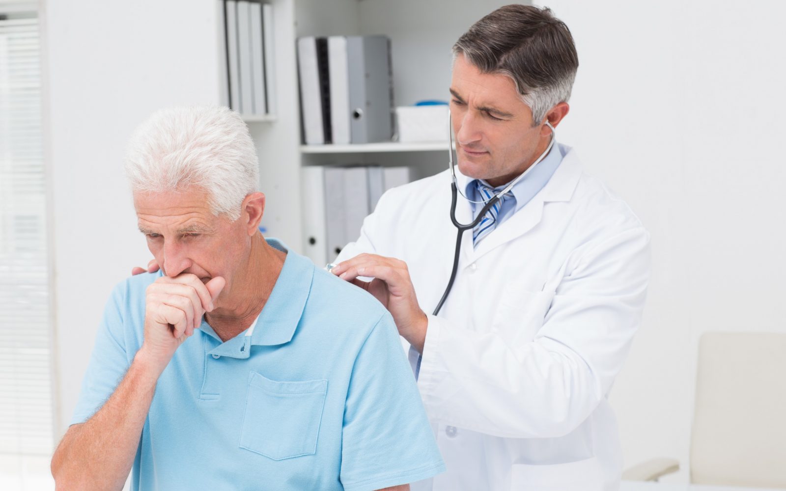 Moški je pa pri zdravniku na pregledu, kašlja