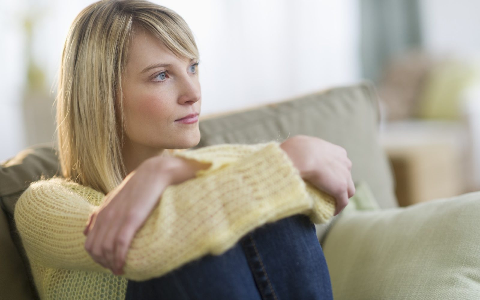 Ženska zamišljeno gleda v daljavo, simbolizira čustveno otopelost in notranjo stisko