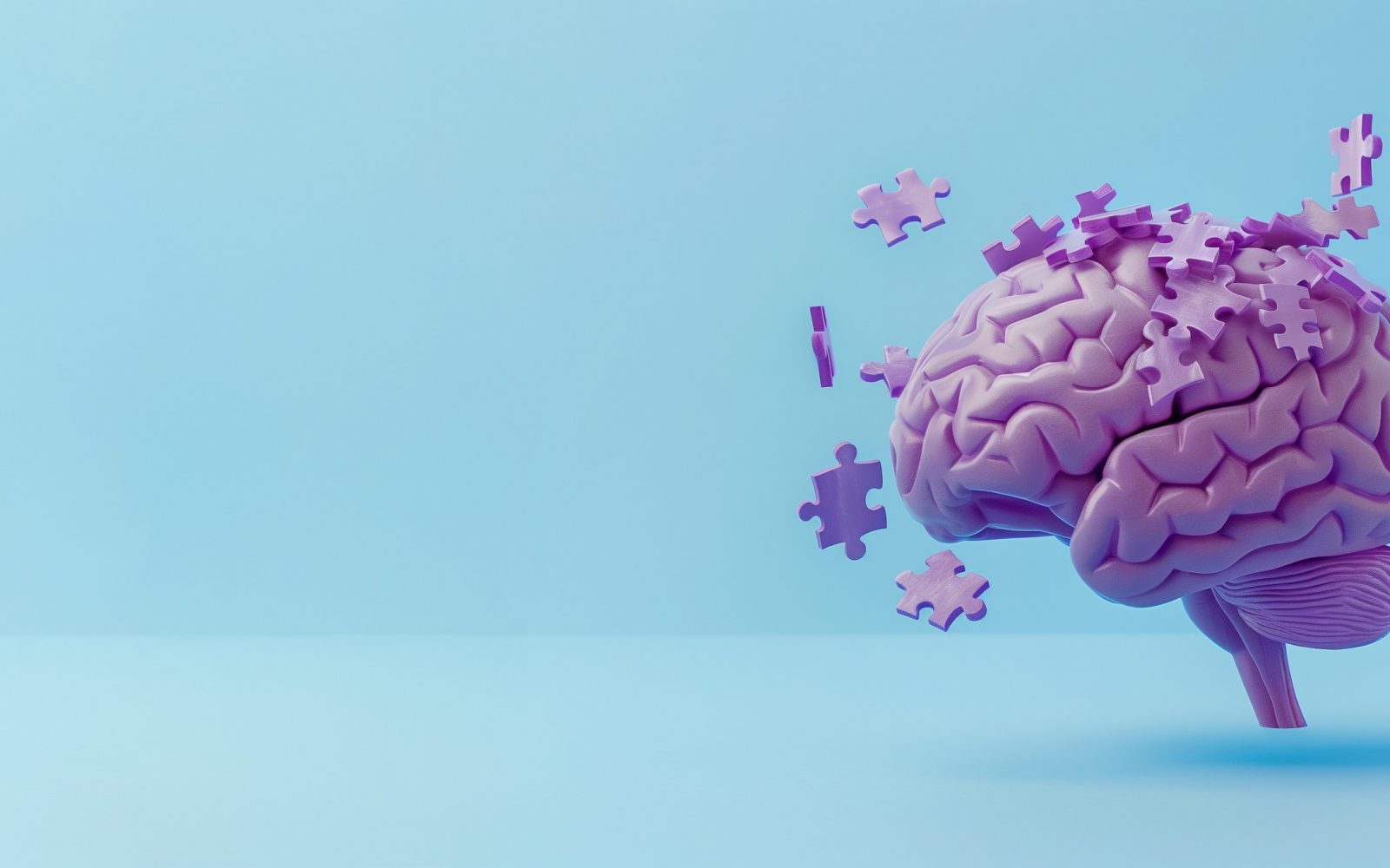 Vizualni prikaz kognitivnega upada in demence. Na modrem ozadju je slika možganov, iz katerih izpadajo koščki sestavljanke.