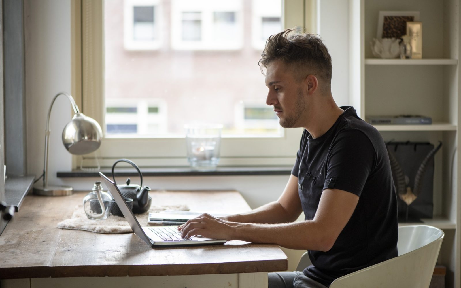 Moški dela na računalniku od doma - motnje pametnega telefona