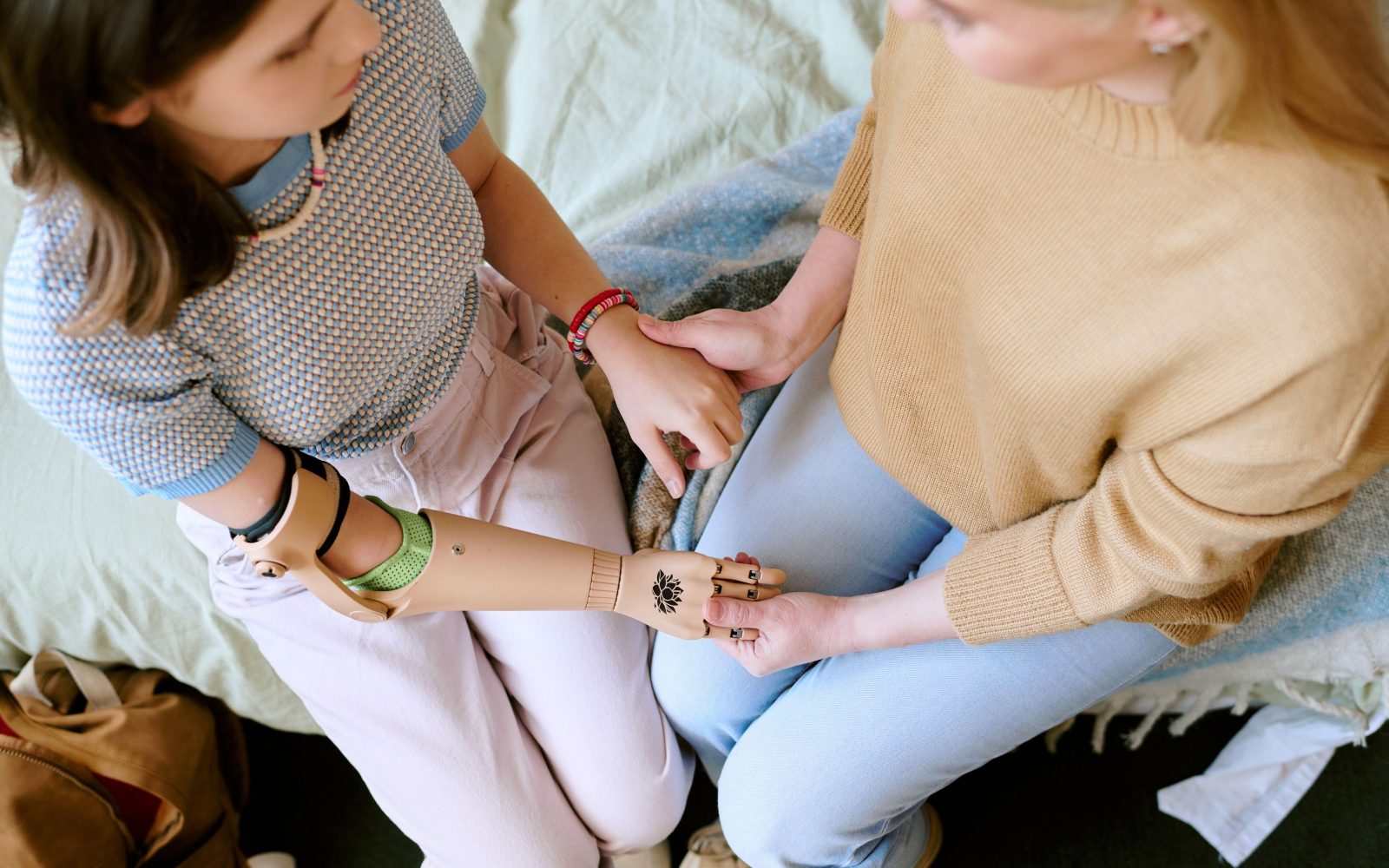 Prijateljska podpora: prijateljici se držita za roke, v znak podpore