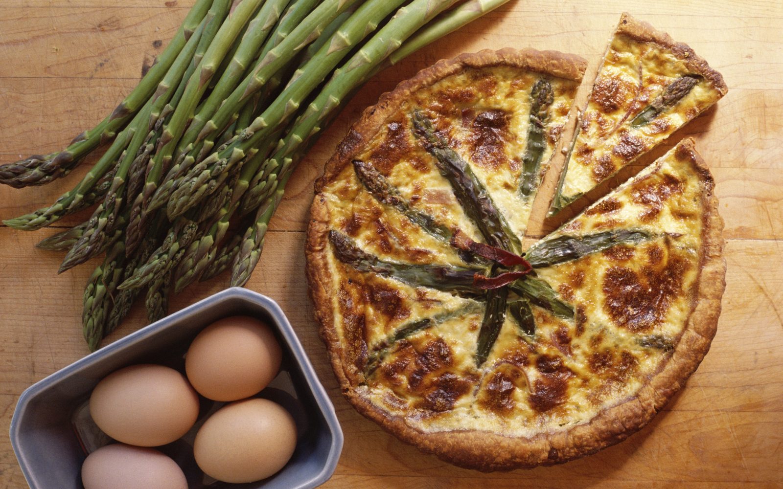 Na mizi je pita iz sveže sezonske zelenjave, špargljev, ki so odlična izbira za pomladne obroke.