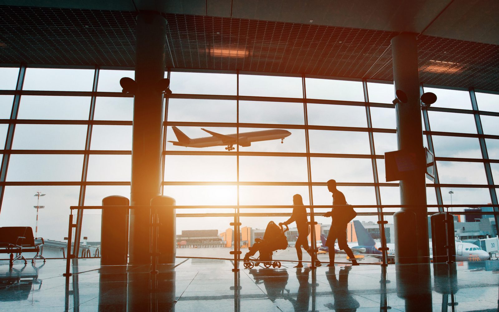 Družina s prtljago in vozičkom na letališču - priprave na udoben in brezskrben let