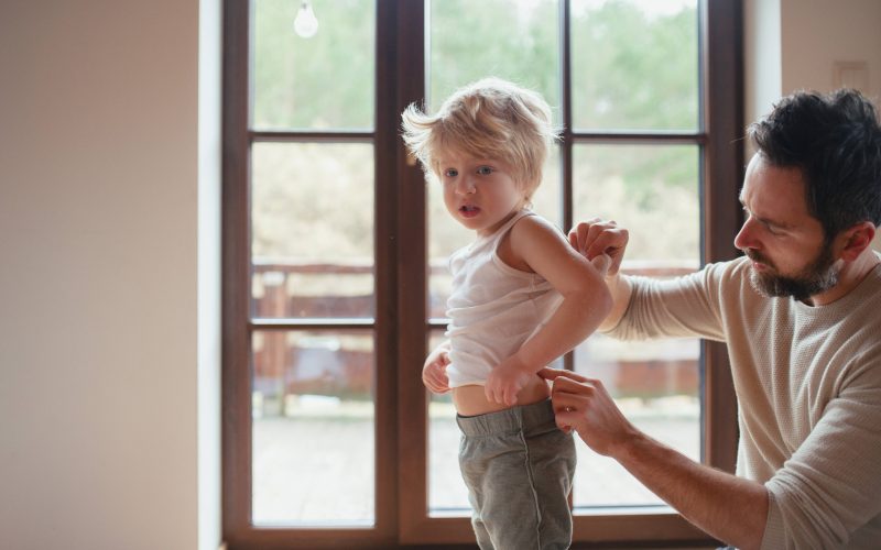 Oče pregleduje kožo od sina, zaščita kože pred soncem, sončne opekline povečajo tveganje za raka