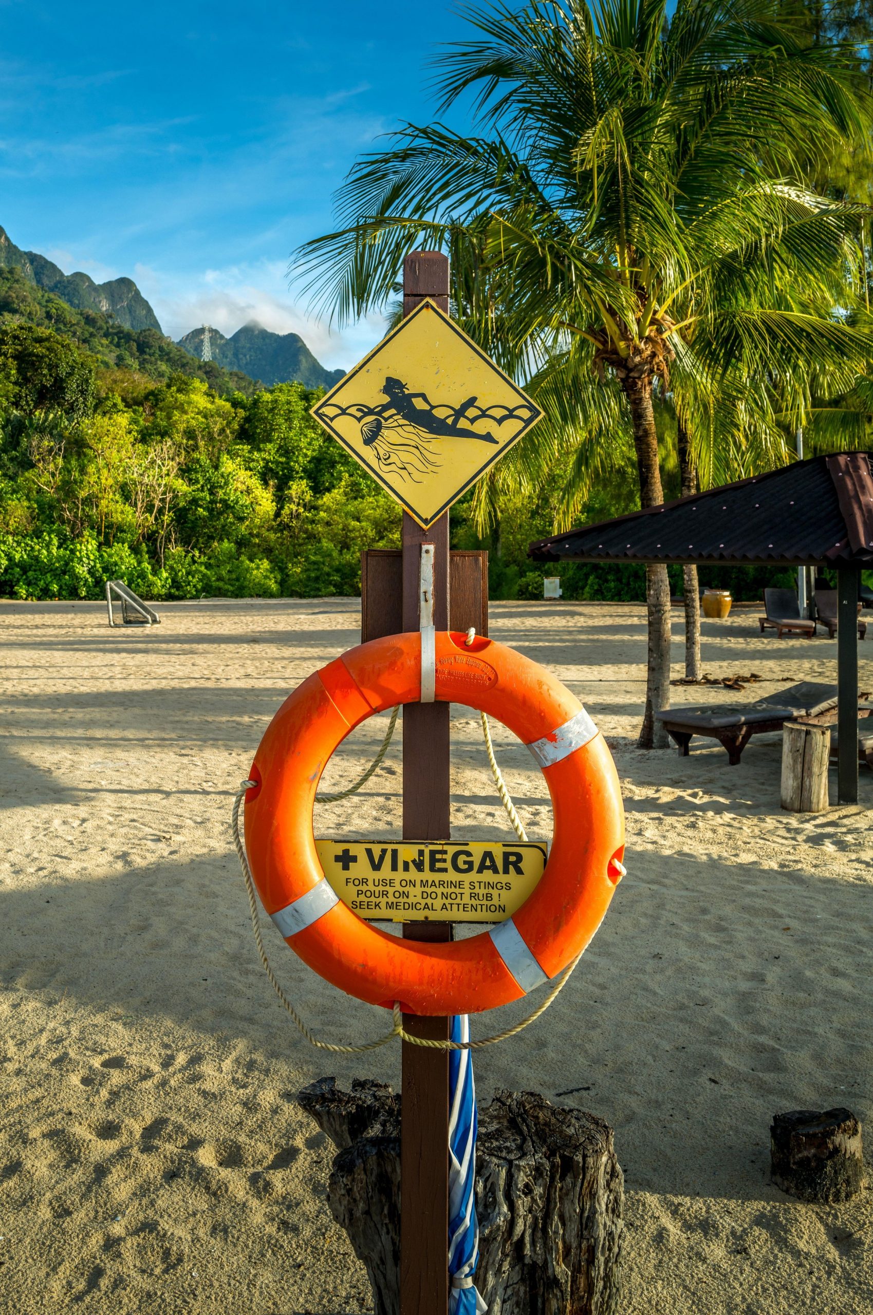 Opozorilni znak za nevarnost meduz in znak za prvo pomoč ob ožigu - kis - na plaži.