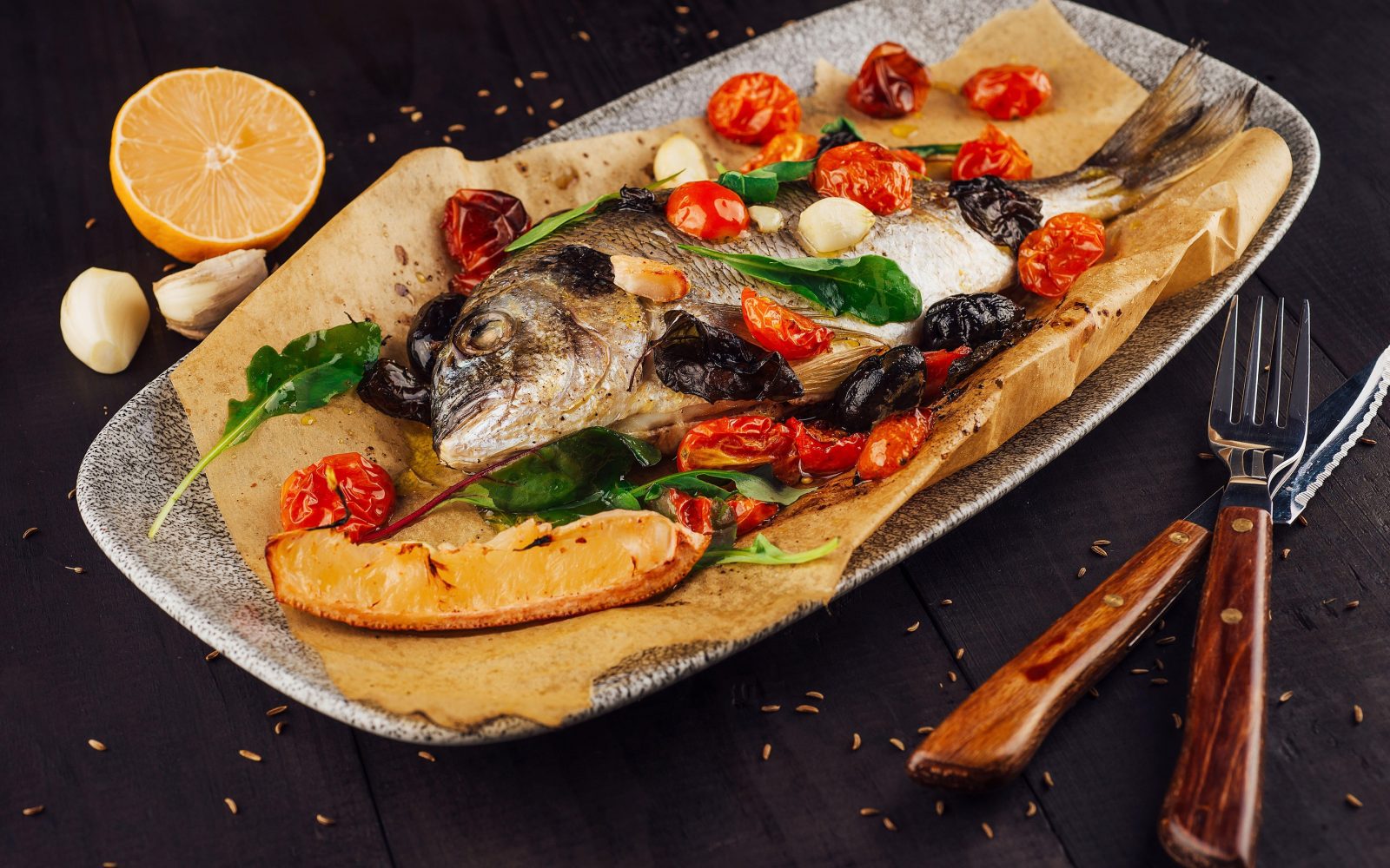 Sveža orada pečena v peki papirju (en papillote) z aromatičnimi zelišči, kosi krompirja, zelenjavo, limono in olivnim oljem.