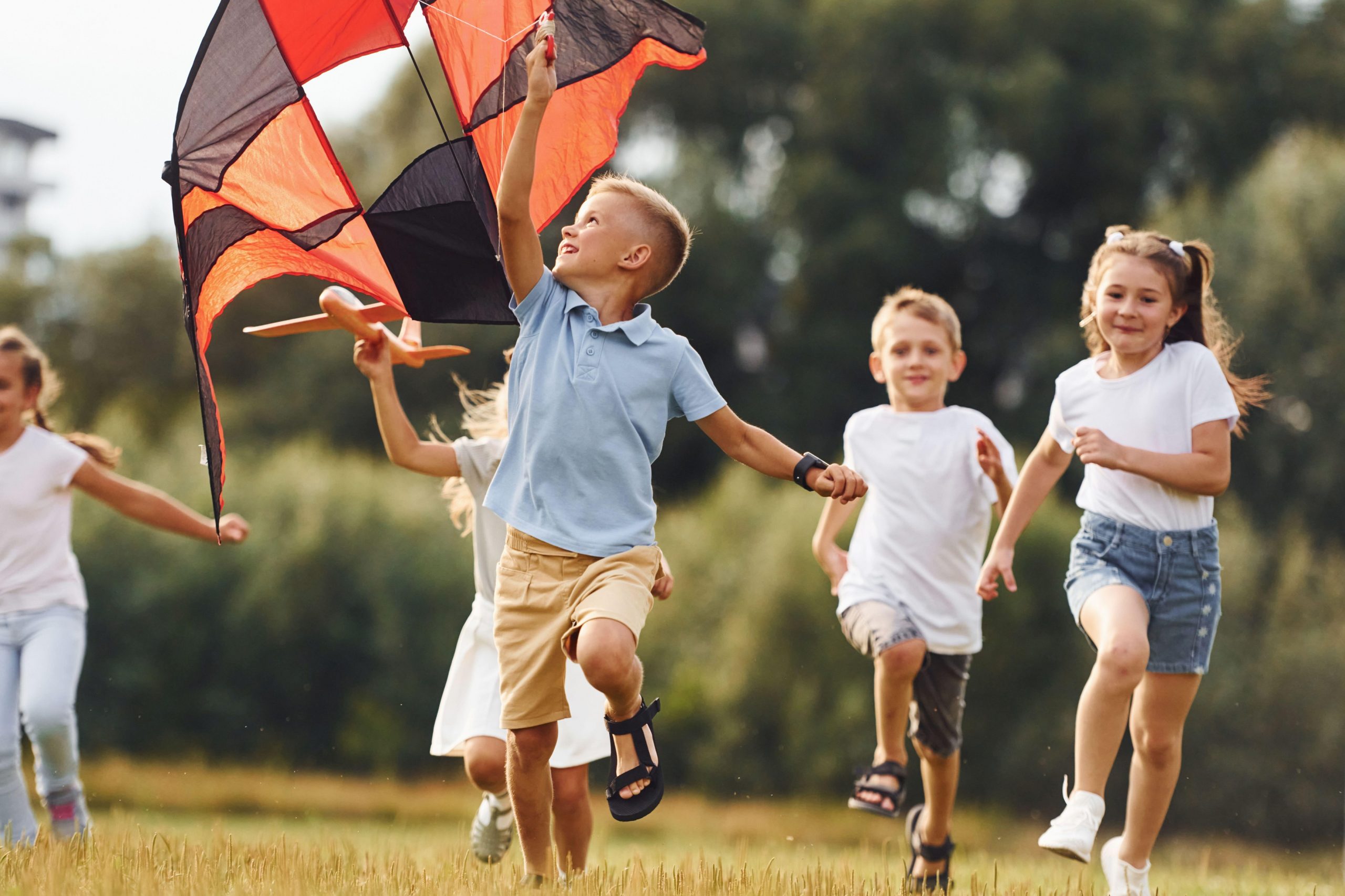 Slika skupine veselih otrok med igro, ki se lahko neobremenjeno gibajo zaradi ustreznega zdravljenja artritisa.