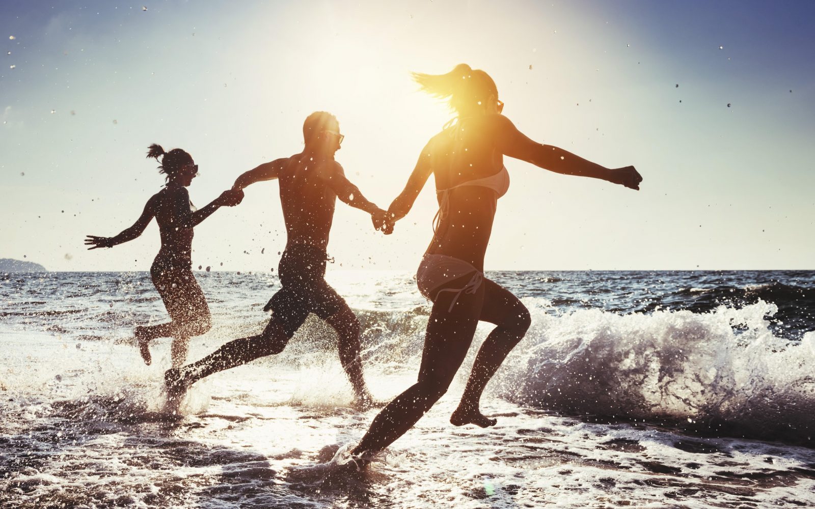 Skupina prijateljev, ki teče v morje po kosilu – varno plavanje po jedi brez strahu pred krči in utopitvijo.